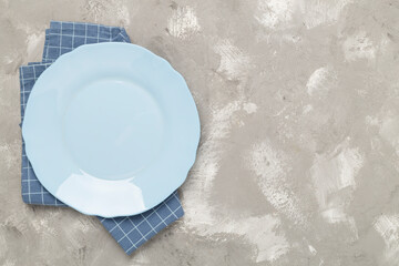 Empty plate with tablecloth on concrete background, top view