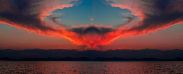 Landscape with red clouds on the blue sky over the lake seen in the mirror. Mirror image of clouds in the shape of a circle in the evening