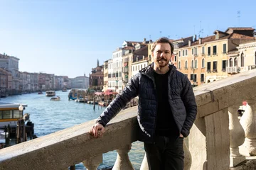 Keuken achterwand Rialtobrug Stylish man in casual wear leaning on the Rialto Bridge in Venice, with the Grand Canal as scenic backdrop  © cabuscaa