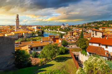 View from the Castel San Pietro of the medieval city of Verona, Italy, with the Cathedral Bell Tower rising above the historic old town along the River Adige under dramatic late afternoon skies.
