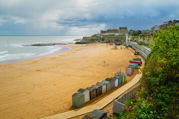 Beach huts along the beautiful sandy Viking Bay beach in Broadstairs, Kent, UK during a cloudy, rainy spring day. . - 798254450