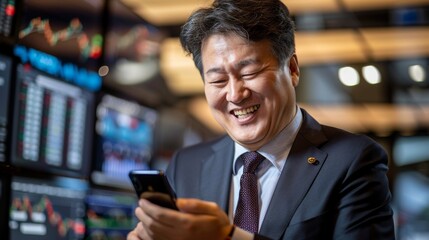 A delighted businessman with infectious laughter using a phone with financial data screens in the background
