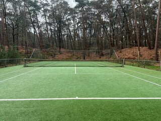 Tennis court with artificial grass and net outdoors