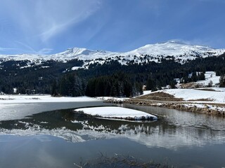 A typical winter idyll on the frozen and snow-covered alpine lake Heidsee (Igl Lai) in the Swiss winter resorts of Valbella and Lenzerheide - Canton of Grisons, Switzerland (Schweiz)