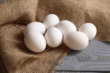 Fresh chicken eggs on grey wooden table, closeup