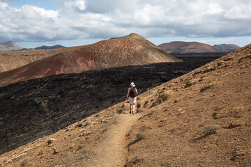 Female hiker at Caldera Blanca volcano slope, Lanzarote, Spain