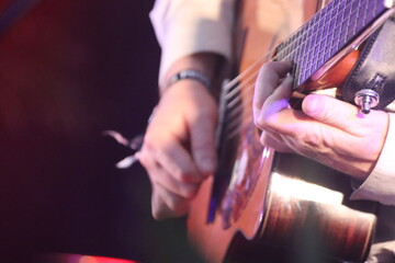 close up person playing acoustic guitar at a concert