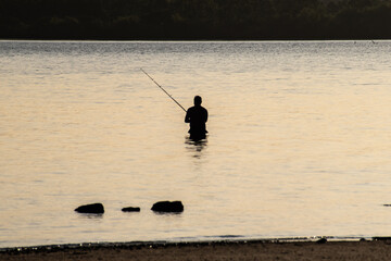 Pescador en un río de Argentina con su caña al atardecer, Entre Ríos, Argentina