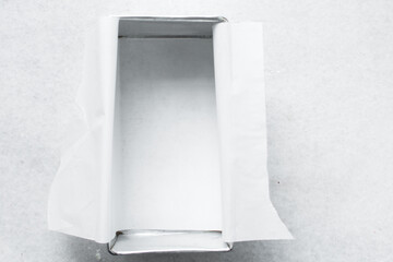 Parchment paper lined loaf baking pan, overhead view of metal loaf pan