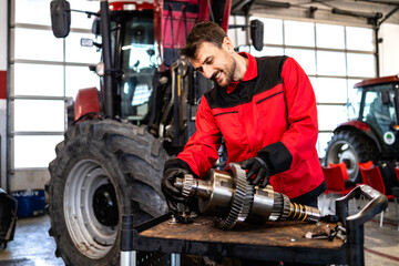 Mechanic repairing and servicing transmission for tractor agricultural machine.
