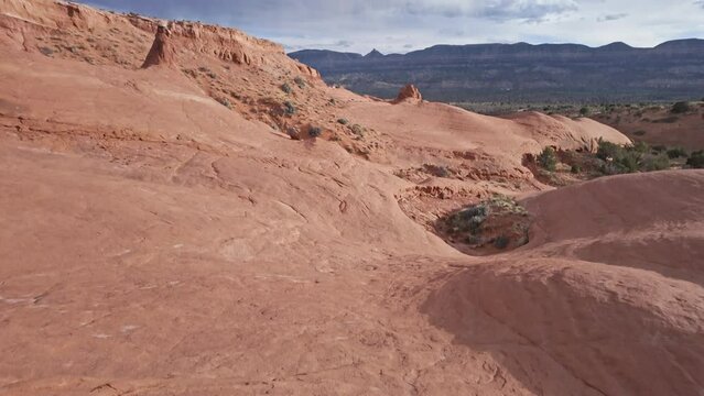 Tilt up over the sandstone terrain in the Escalante desert as storm moves in the background.