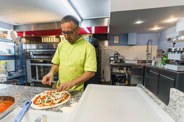 chef in green uniform preparing pizza in pizzeria kitchen, italian cuisine. High quality photo