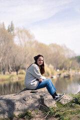 Mujer joven sentada junto al lago