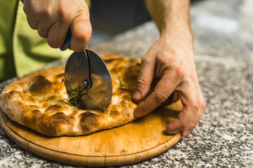 closeup shot of a chef cutting impala pizza, bakery concept. High quality photo