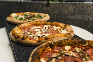 different pizza set for menu on the wooden table. Italian food traditional cuisine. Pizzas with ham, bacon, olives and mushrooms. High quality photo