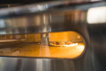 shot of a pizza baking in an electric oven, italian food, bakery concept. High quality photo