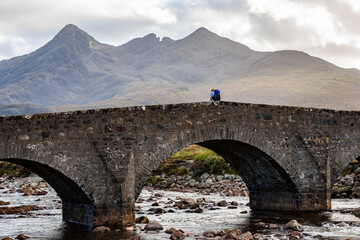 Sligachan Bridge, Isle of Skye, Scotland, with Cuillin Mountains and orange clouds on backround in sunset light, Isle of Skye, Scotland