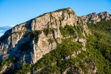 Fototapeta na wymiar Sicevo Gorge (Sicevacka klisura) in Serbia. The gorge in the middle of mountains. A view of the huge rocks that rise above the gorge.
