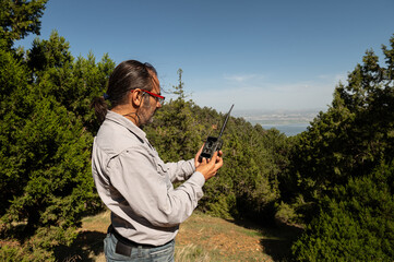 A man checking a photo trap in the forest for wild animals.