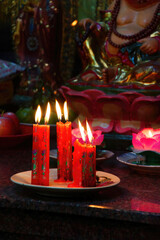Votive candles and incense, with Buddha