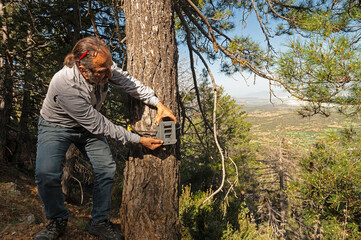 A man who placed a photo trap in a tree to film wild animals.