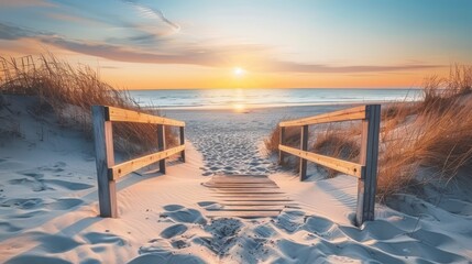 Fototapeta na wymiar Beautiful sand dune beach at sunset with wooden bridge