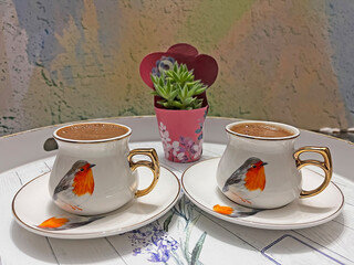 Traditional Turkish coffee in bird patterned cups.