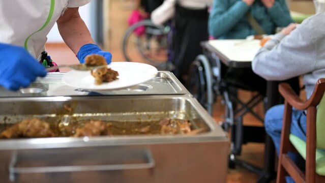 Close up of a Nurse serving food to senior people at nursing home. High quality 4k footage