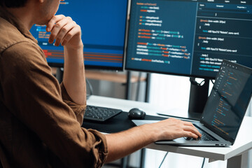 IT developer working online software development on pc monitors at modern home office on coding...