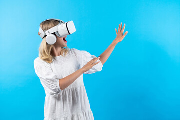Skilled girl in pajamas excited with metaverse by using VR goggle at background. Caucasian woman...