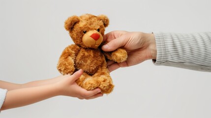 大人から子供に熊のぬいぐるみを渡す
