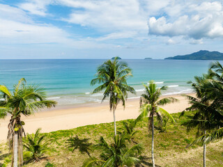 Duli Beach with coconut trees and ocean waves over the sands. El Nido, Philippines.