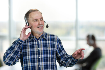Portrait of happy male call center customer support worker. Office enviroment background.