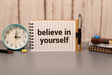 Believe In Yourself, written on an yellow sticky note on a cork bulletin board