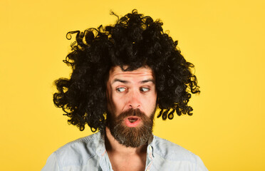 Portrait of surprised bearded man in black wig. Party time. Stylish male model with beard and...
