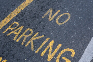 No parking yellow sign on asphalt road or street.