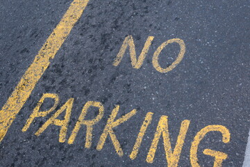 No parking yellow sign on asphalt road or street.