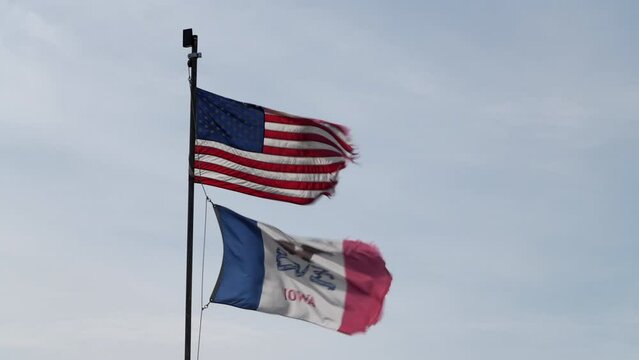 American and State of Iowa flags proudly waving and fluttering on a strong wind