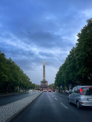 victory column on the avenue of 17 June in Berlin, at the blue hour in a day with stormy sky, a car...