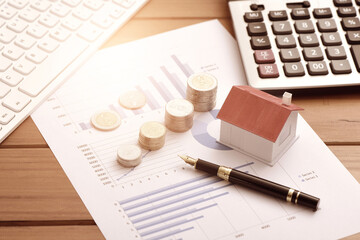 Coins, small houses, calculators, and computer keyboards placed on data sheets