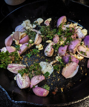 onions and herbs in a cast iron pan