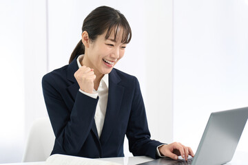 パソコンの前でガッツポーズをする女性