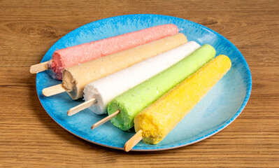 Colorful and tasty Indian or Pakistan kulfi, an ice treat on a stick
