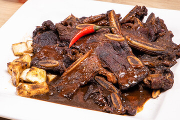 Pieces of smoked beef short ribs on a white plate