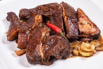 Pieces of smoked chicken on a white plate