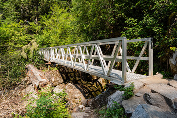 Metal bridge over the little river or mountain creek and hiking trail in provincial park Fraser Valley British Columbia - obrazy, fototapety, plakaty