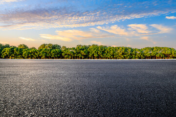 Asphalt road and green trees with sky clouds natural landscape at sunset