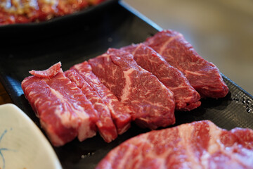 Thickly sliced ​​fresh beef sirloin on black plate