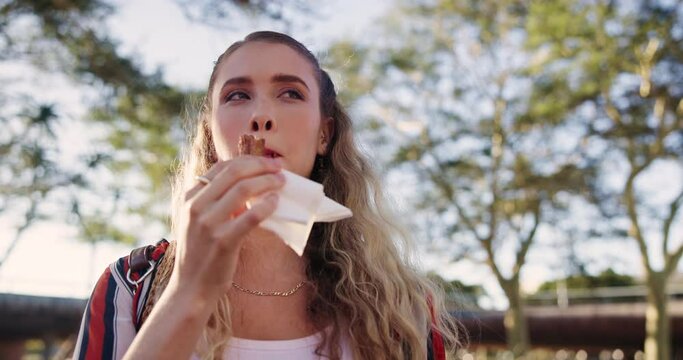 Dessert, woman and eating churro, food or snack outdoor at park in nature for breakfast or cuisine in the morning alone. Sweets, pastry and hungry person enjoying meal, treat and sugar at garden