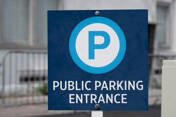 blue public parking entrance sign in front of a city lot